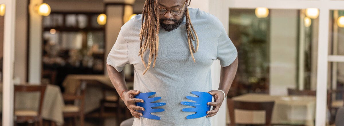 Homem se abraçando com mãos de papel